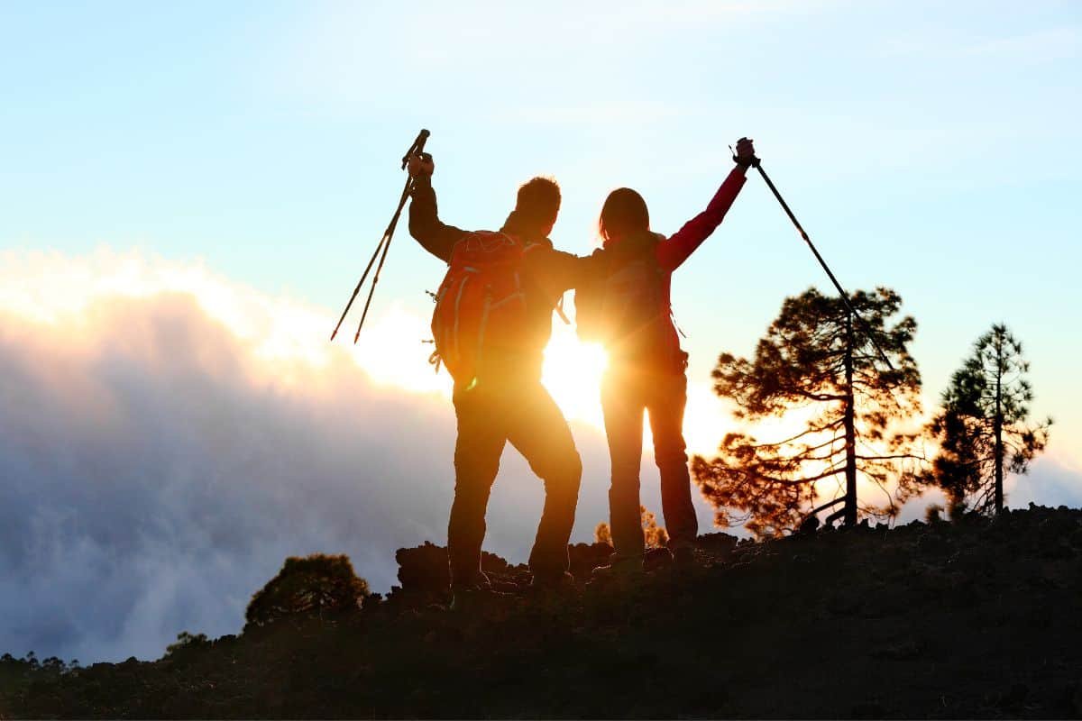 a couple in the sunset feeling accomplished