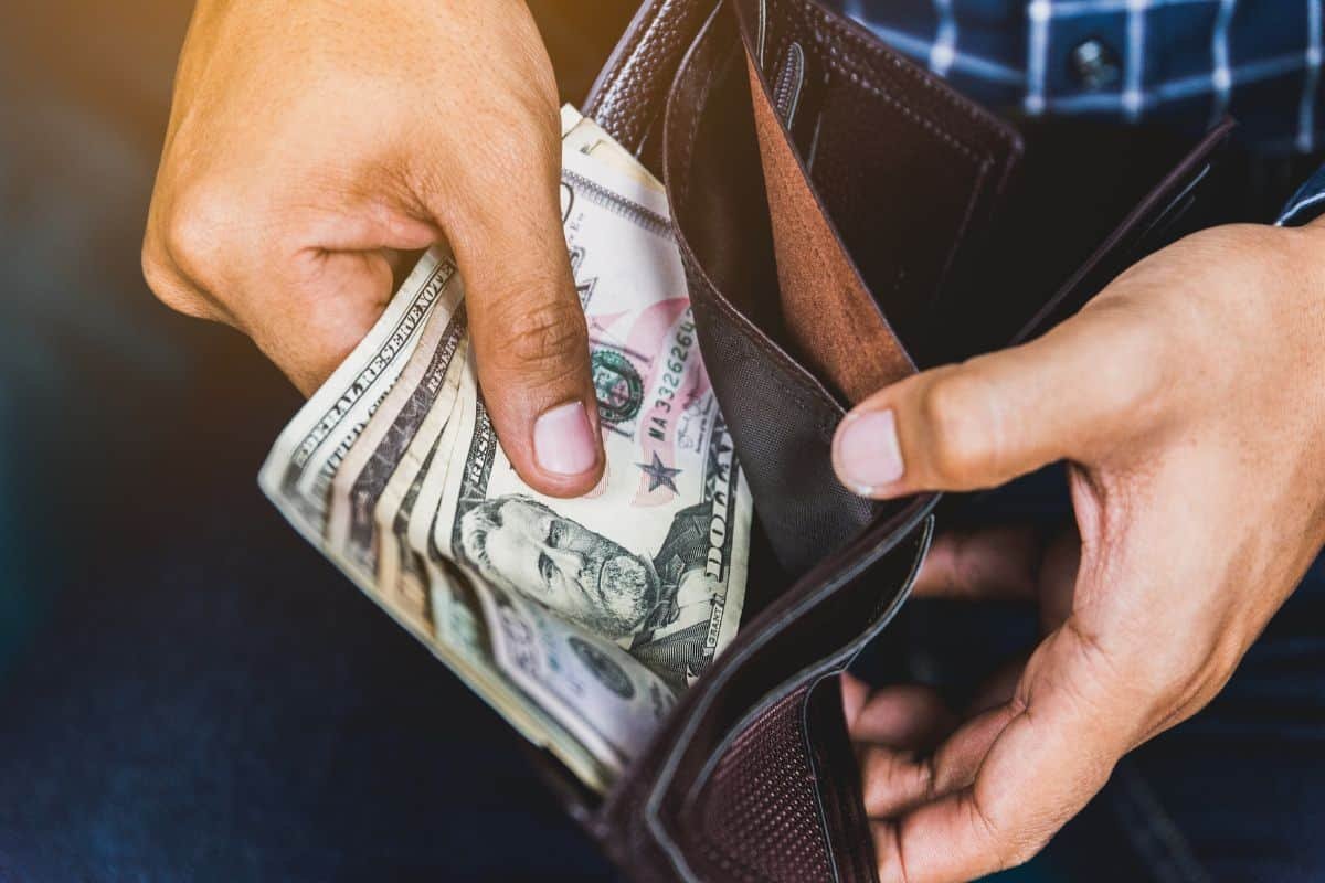 a man checking bank notes in his wallet