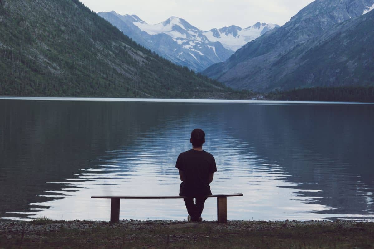 a man sitting on a bench in nature