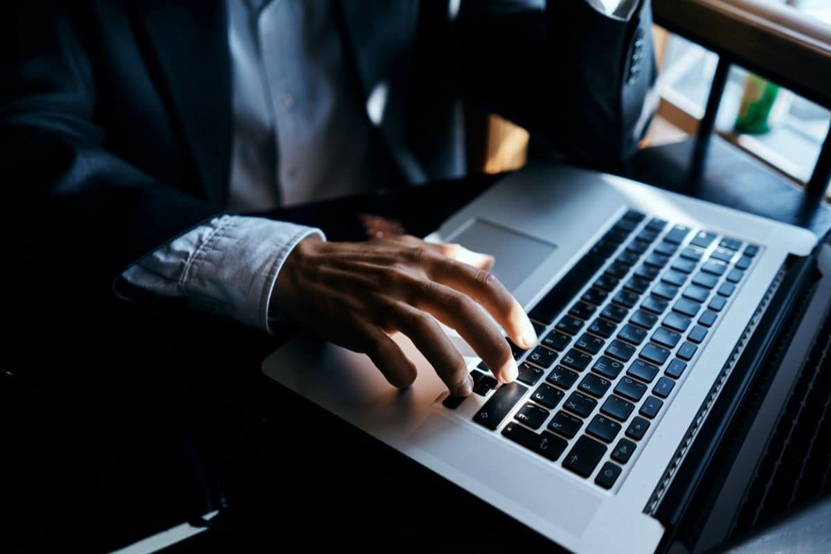 black man working on a silver laptop