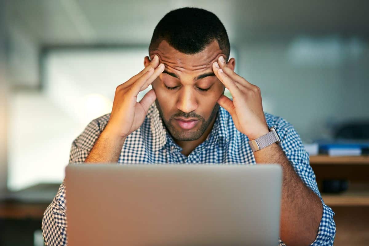 stressed man behind a laptop