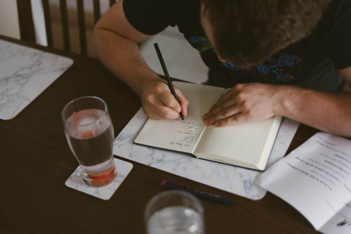 man writing in a journal