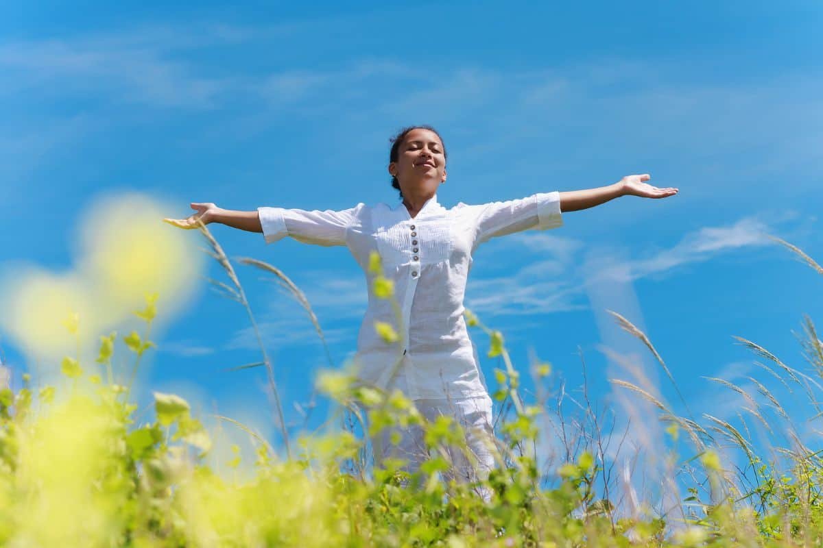 woman enjoying the sunshine in a field